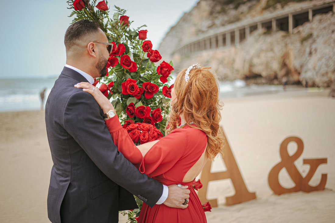 Novios abrazados en su Bride to be Playa con rosas. Decoración y organización de Hikayat Events